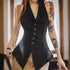 Person wearing a black sleeveless blazer with tattoos on arms, indoors.
